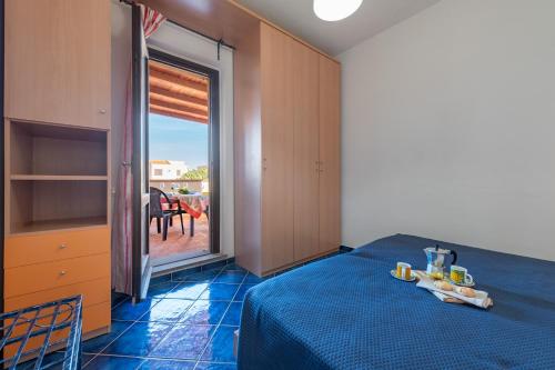 Schlafzimmer mit einem Bett und einer Glasschiebetür zur Terrasse in der Unterkunft AffittaSardegna-Trilo La pelosa in Stintino