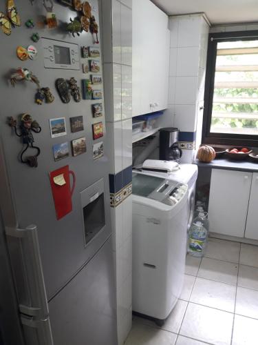 a kitchen with a refrigerator with magnets on the wall at B&B Santo Domingo Chile ENGLISH SPOKEN Gran Departamento compartido frente al mar PARQUE TRICAO bird sanctuary 14kms 9miles away DESAYUNO ESTACIONAMIENTO Y WIFI GRATIS Free parking wifi and breakfast in Santo Domingo