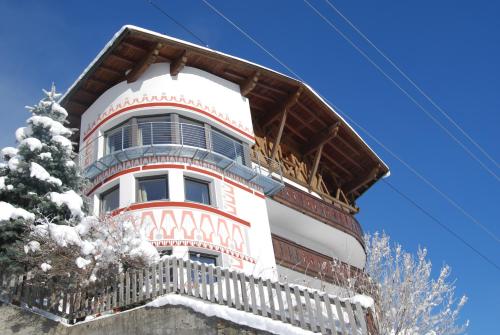 a tall white building with a balcony in the snow at Apart Stotter in Kappl
