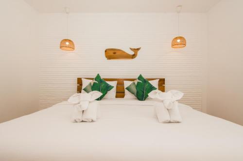 een wit bed met twee knuffels erop bij Whalecome Aonang Resort-SHA Extra Plus in Ao Nang Beach