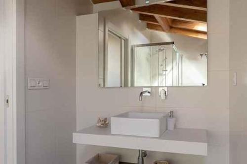 Un baño con un lavabo blanco y un espejo. en Mercedes Etxea, en Cripán