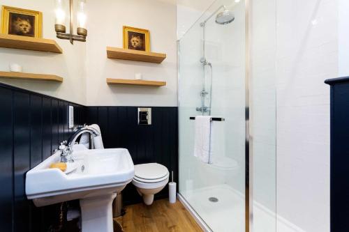 a bathroom with a sink and a toilet and a shower at Veeve - Sinclair Sophistication in London