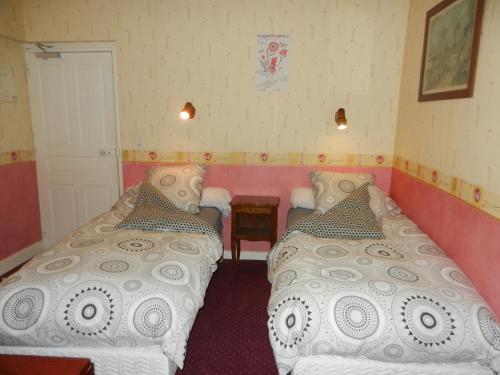 a small room with two beds and a table at Auberge de la Tradition in Corrèze