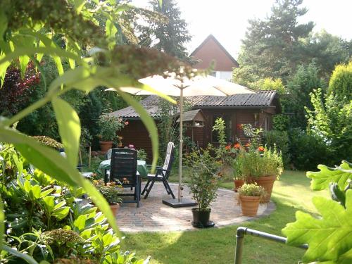 a garden with a gazebo and a chair and an umbrella at Haus Petersen in Undeloh
