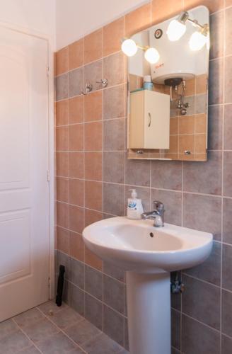 a bathroom with a sink and a mirror at Felicia's sun-side house in Kastraki