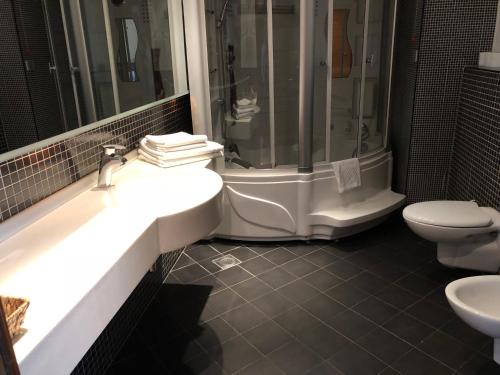 a bathroom with a sink and a shower and a toilet at Hotel Exclusive in Sarajevo