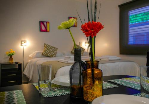 una habitación con una mesa con flores en un dormitorio en Umbral del Aconcagua en Mendoza
