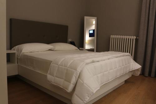 a bed with white sheets and pillows in a bedroom at Boutique Hotel Palazzo Corso Umberto in Boiano