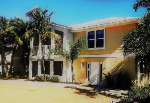 a house with palm trees in front of it at Escape Coastal Resort on Casey Key in Nokomis