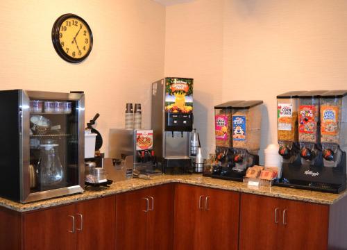 a kitchen with a counter with a clock on the wall at Baymont by Wyndham Effingham in Effingham