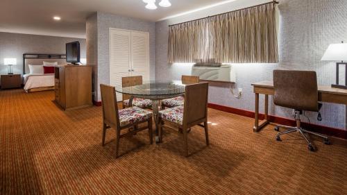 a hotel room with a table and chairs and a bed at SureStay Hotel by Best Western Camarillo in Camarillo
