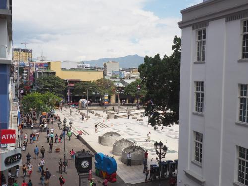 uma multidão de pessoas andando em torno de uma praça em uma cidade em Nuevo Maragato Hotel & Hostel em San José