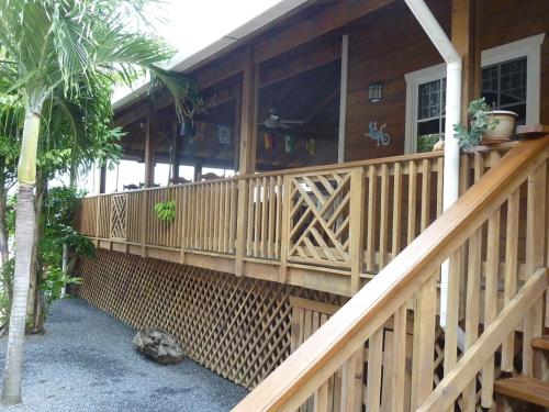a wooden porch on a house with a palm tree at Wikkid Resort in Dixon Cove