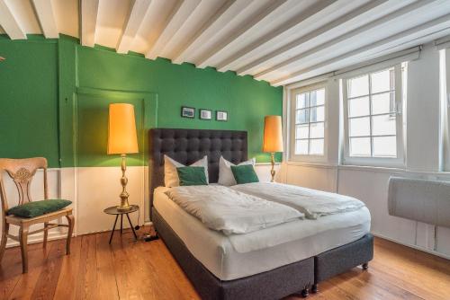 ein Schlafzimmer mit einem Bett mit einer grünen Wand in der Unterkunft Privatzimmer in bester Altstadtlage in Tübingen