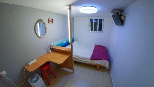 een kleine slaapkamer met een bed en een spiegel bij Private place near carmel center in Haifa