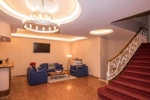 a living room with blue couches and a staircase at Evenia Oros in Encamp