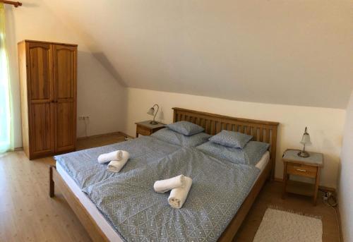 a bedroom with a bed with two towels on it at Kristály Apartmanház in Sárvár