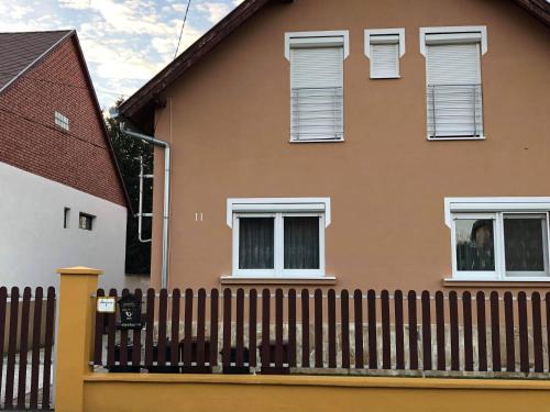 a house with a picket fence in front of it at Kristály Apartmanház in Sárvár