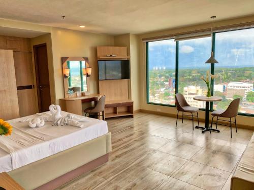 um quarto de hotel com uma cama, uma mesa e cadeiras em New Dawn Plus em Cagayan de Oro