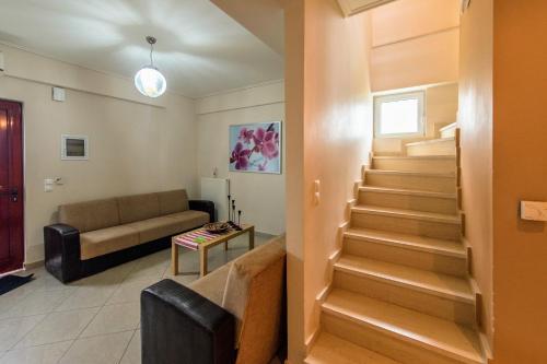 a living room with stairs and a couch at SEMIRAMIS SUITES with pool in Kalamata