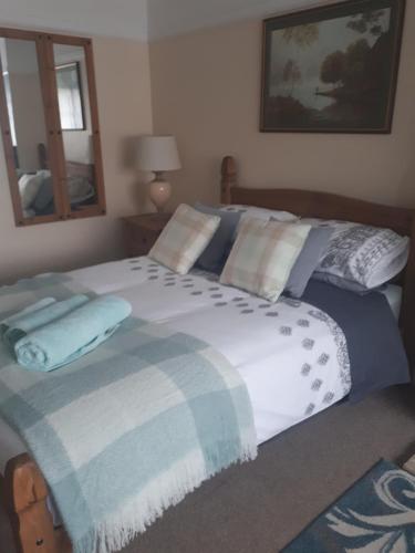a bedroom with a large bed with a blue and white blanket at Honington Fox Inn in Bury Saint Edmunds