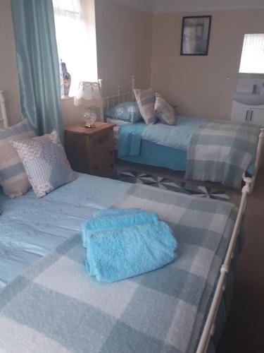 a bedroom with two beds and a blue towel on it at Honington Fox Inn in Bury Saint Edmunds