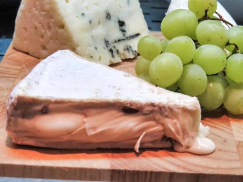 a block of cheese and grapes on a cutting board at Center Chic Hotel - an Atlas Boutique Hotel in Tel Aviv