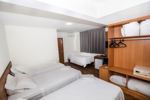 En eller flere senge i et værelse på Vertentes Suítes Hotel