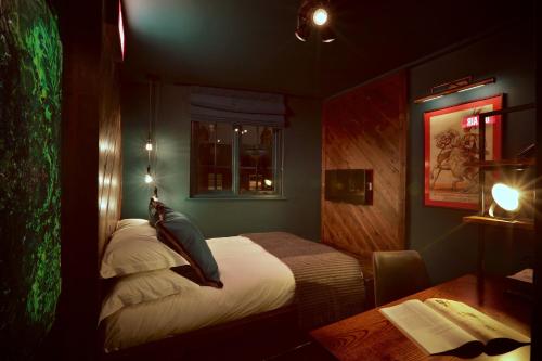 a bedroom with a bed and a desk with a desk at The Bedford Balham - Live Music Venue in London
