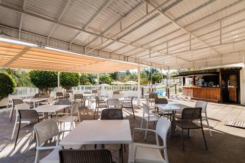 圣阿古斯丁Hotel Folias San Agustín的一个带桌椅的户外庭院和一间酒吧