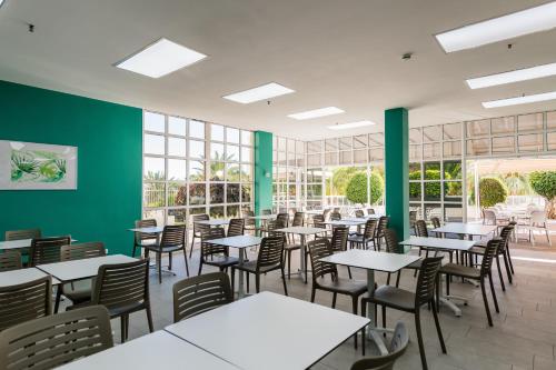 圣阿古斯丁Hotel Folias San Agustín的用餐室设有桌椅和绿色的墙壁
