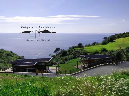 a view of a building with the ocean in the background at Knights in Residence in Tutukaka