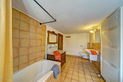 a bathroom with a tub and a toilet and a sink at Ferienhaus Königskerze in Wißmannsdorf