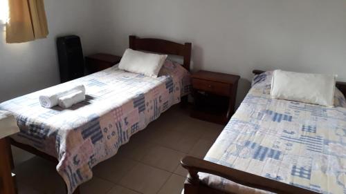 Bosysol en las sierras في ميرلو: غرفة نوم بسريرين وطاولة وكراسي
