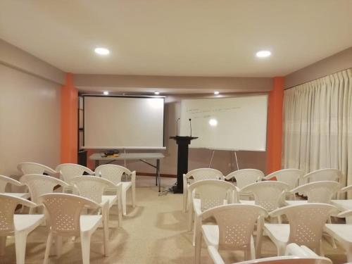 una sala de conferencias con sillas blancas y pizarra en The Oruro Inn, en Oruro