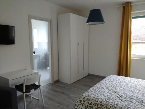 a bedroom with a bed and a desk and a television at Novantatrè in Campobasso