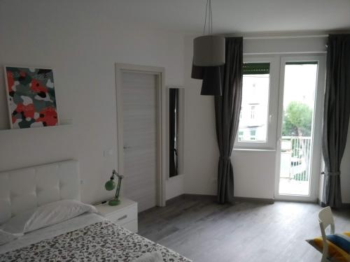 a white bedroom with a bed and a window at Novantatrè in Campobasso