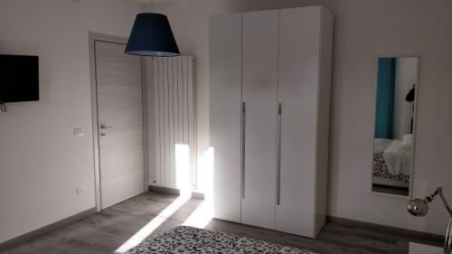 a bedroom with white cabinets and a blue lamp at Novantatrè in Campobasso