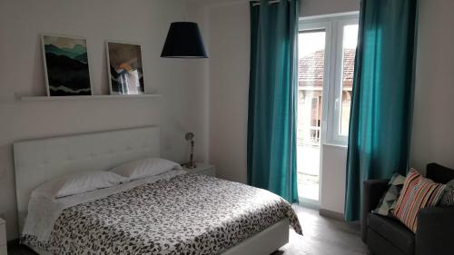 a bedroom with a bed with blue curtains and a window at Novantatrè in Campobasso
