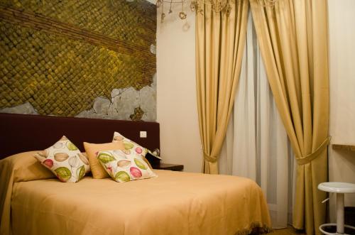 um quarto com uma cama com lençóis e almofadas amarelas em B&B Sosta Flegrea em Nápoles