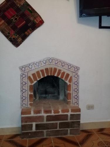 San Antonio PalopóにあるHotel Nuestro Sueñoの壁画のレンガ造りの暖炉