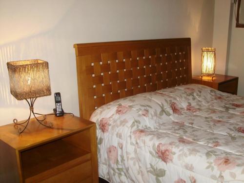 a bedroom with a bed and a lamp on a nightstand at Casa Caminho do Corcovado - Pet friendly in Rio de Janeiro