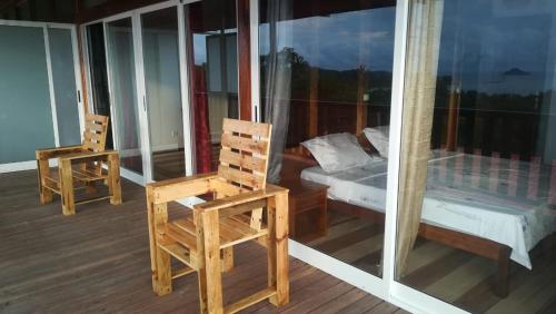 a room with two chairs and a bed on a balcony at Domus Guesthouse in Santana