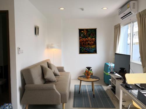 ジョムティエンビーチにあるTrio Gems Condo Pattaya, Thailandのソファとテーブルのあるリビングルーム