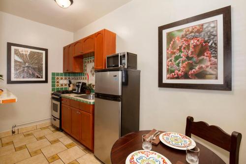 a kitchen with a stainless steel refrigerator and a table at El Cordova in San Diego