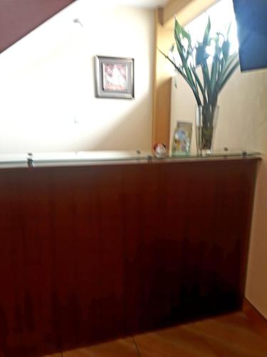 a wooden counter with a vase on top of it at El Marquez in Tacna