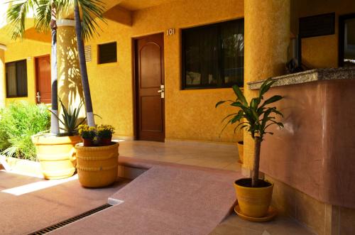 a house with potted plants in front of a door at Villas La Lupita in Acapulco