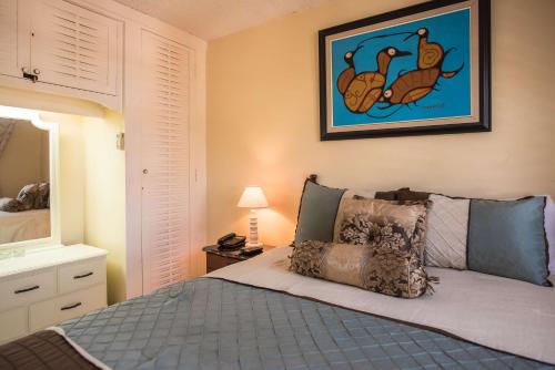 a bedroom with a bed and a picture on the wall at Sandcastles Beach Suites in Ocho Rios