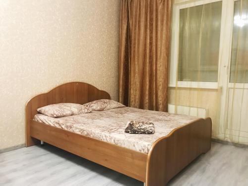 スルグトにあるTyumenskiy trakt 6/1の窓付きの部屋の木製ベッド1台
