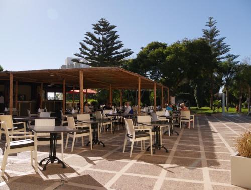 a restaurant with tables and chairs on a patio at Odyssee Park Hotel in Agadir